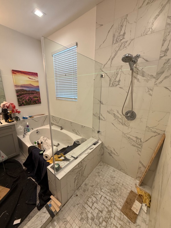 Notched shower glass panel set on a tiled bench during installation