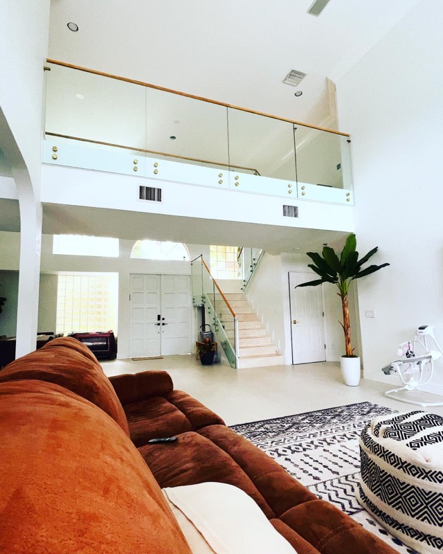 Glass balcony railing with a wood top rail above a living room