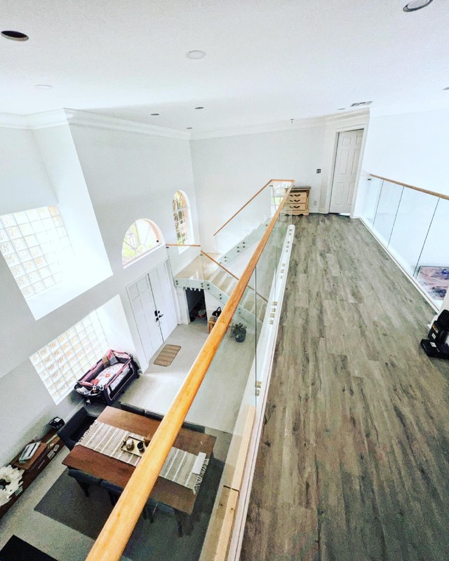 Upstairs balcony glass railing with a wood handrail