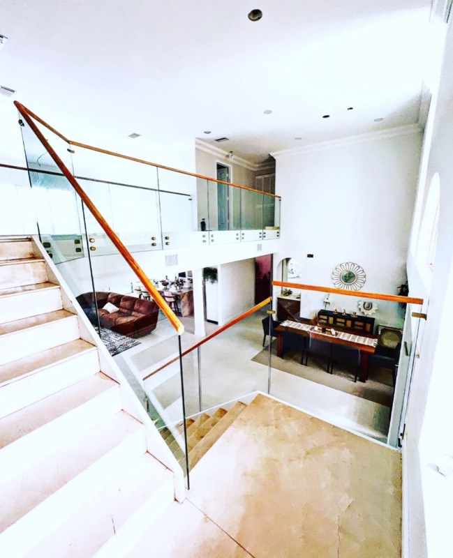 Glass railing on a staircase landing overlooking the living room