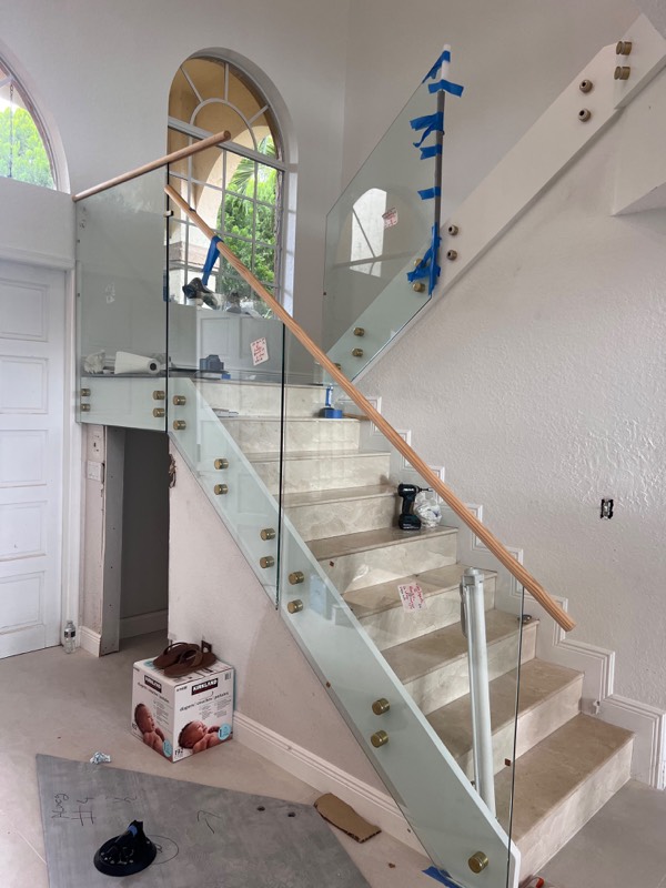 Glass stair panels and wood handrail during installation