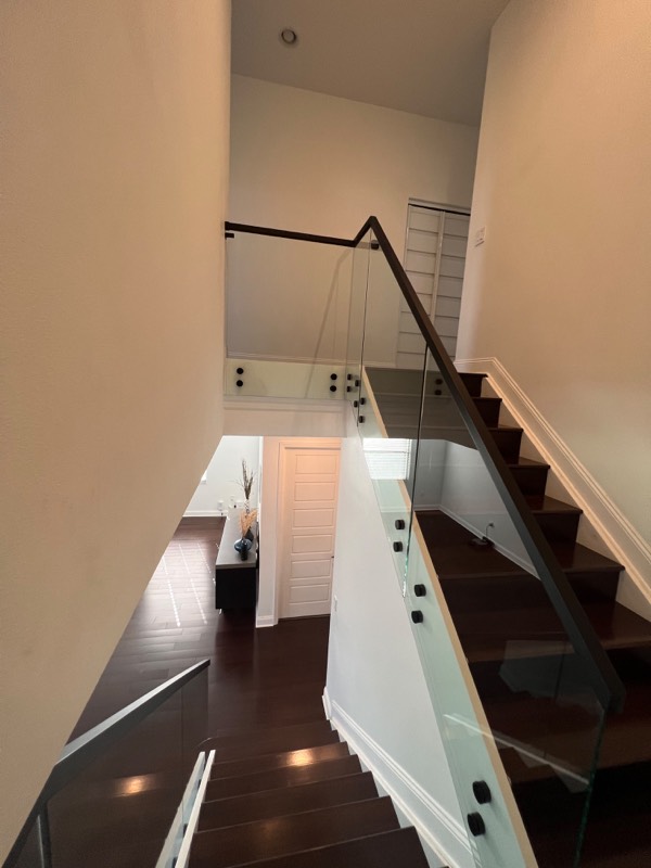 Glass stair railing looking down from the upper landing