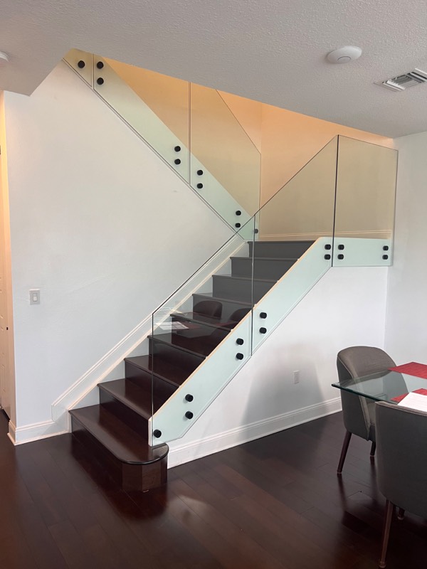 Glass stair railing panels installed before the handrail was added