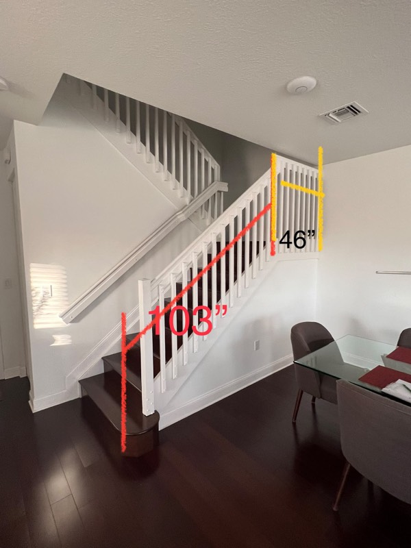 Staircase with wood balusters and marked measurements before the glass railing
