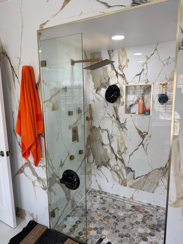 Fixed shower glass panel being set in a marble shower