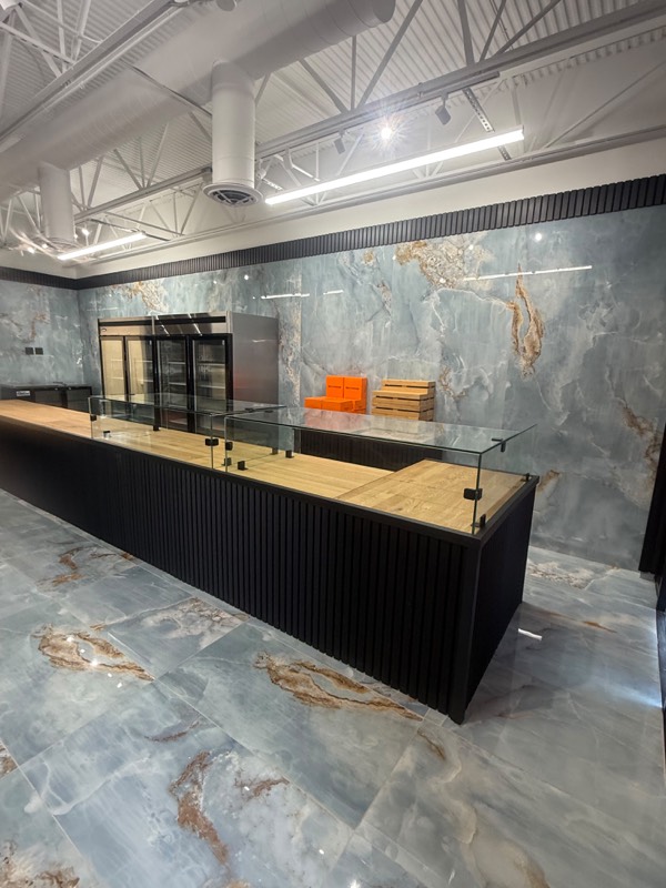 Shop counter with a glass guard running along the customer side
